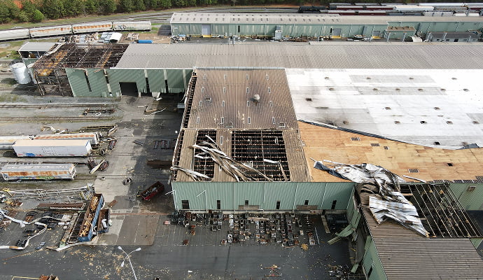 Large commercial property with storm-damaged roof Large commercial property showing extensive roof damage caused by a severe storm
