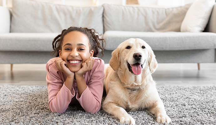 Girl with puppy on clean rug Girl with puppy on clean rug