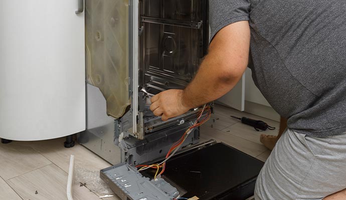 Technician repairing a dishwasher