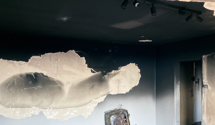 Smoke-stained ceiling and walls in a damaged room