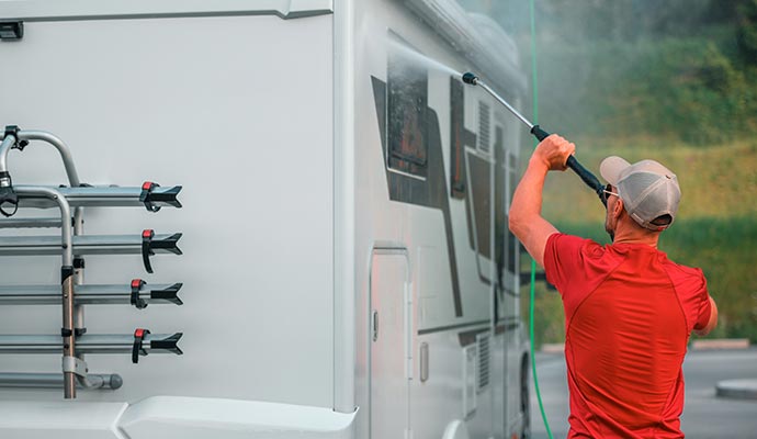 a person cleaning an rv using pressure wash